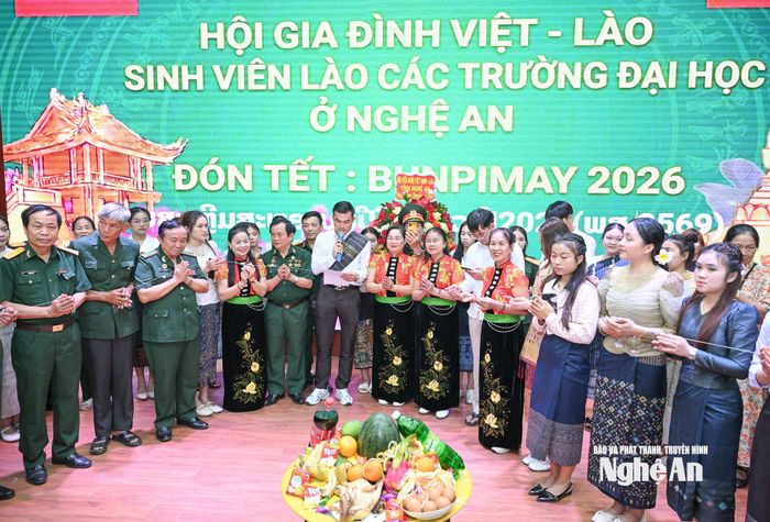 Các sinh viên người Lào cùng Hội cha mẹ Việt - Lào tham gia nghi thức buộc chỉ cổ tay mừng Tết Bunpimay. Ảnh tư liệu: Thành Cường