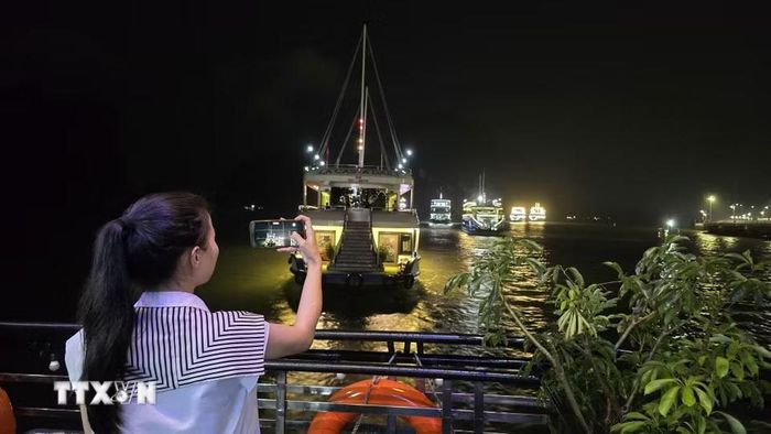 Du khách háo hức chiêm ngưỡng vẻ đẹp lung linh của Di sản thiên nhiên Thế giới vịnh Hạ Long về đêm. (Ảnh: Thanh Vân/TTXVN)