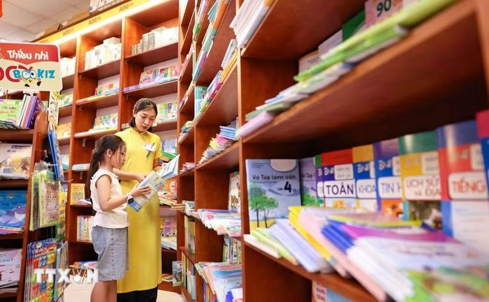 Phụ huynh và học sinh chọn mua sách. (Ảnh: Thanh Tùng/TTXVN)