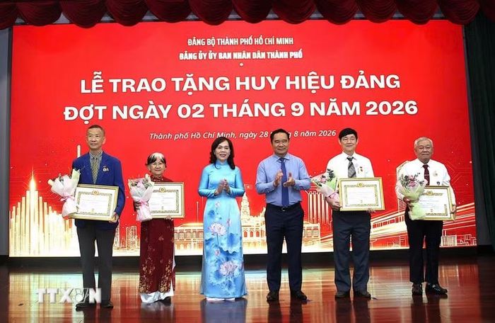 Trao Huy hiệu 45 năm tuổi Đảng cho các đảng viên. (Ảnh: Liên Sơn/TTXVN)