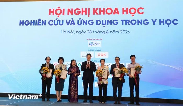 Ban tổ chức tặng hoa cho các báo cáo viên tại Hội nghị. (Ảnh: PV/Vietnam+)