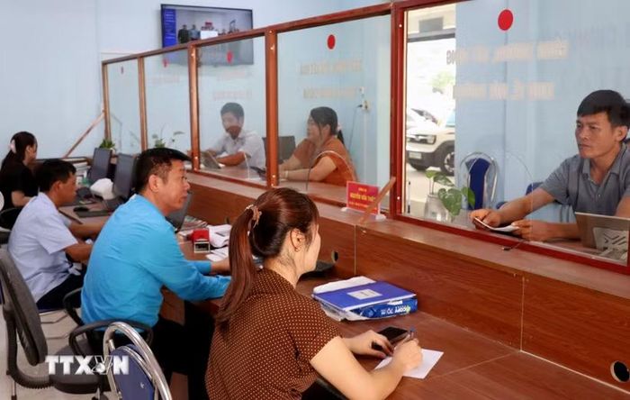 Cán bộ Trung tâm Phục vụ hành chính công xã Lao Chải (Tuyên Quang) hướng dẫn, giải quyết thủ tục hành chính cho người dân. (Ảnh: Đức Thọ/TTXVN)
