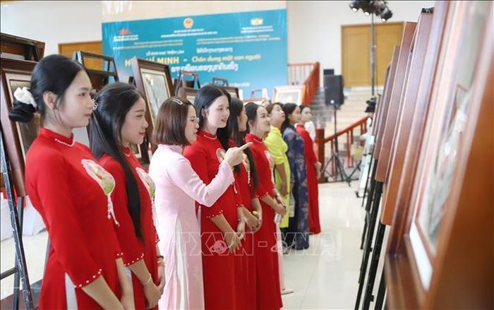 Cô giáo Trường Song ngữ Lào - Việt Nam Nguyễn Du giới thiệu cho học sinh về Bác Hồ tại Triển lãm. Ảnh: Xuân Tú/TTXVN
