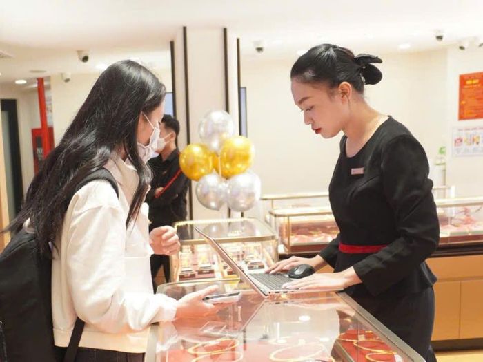 Nhân viên cửa hàng tư vấn sản phẩm vàng cho khách hàng. Ảnh: Nguyễn Hoàng/Báo Tin tức và Dân tộc
