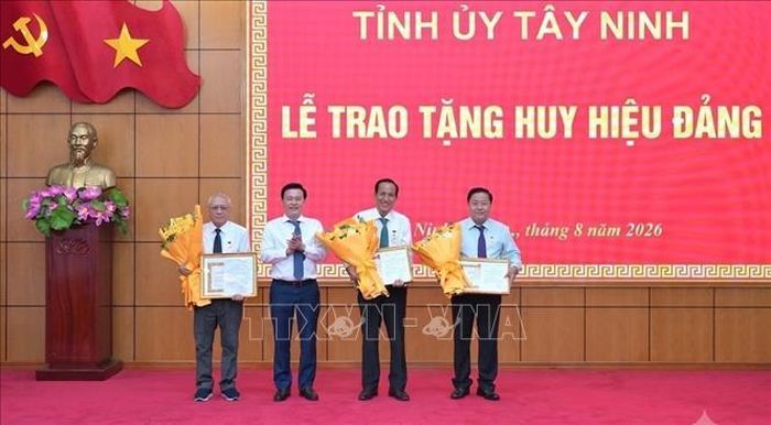 Phó Bí thư Tỉnh ủy, Chủ tịch Ủy ban Mặt trận Tổ quốc Việt Nam tỉnh Tây Ninh Nguyễn Thanh Hải trao Huy hiệu Đảng cho các đảng viên. Ảnh: Thanh Bình/TTXVN