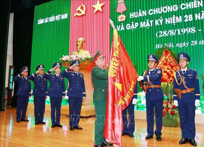 Thượng tướng Nguyễn Quang Ngọc, Ủy viên Trung ương Đảng, Thứ trưởng Bộ Quốc phòng gắn Huân chương Chiến công hạng Nhất lên Quân kỳ Quyết thắng của Cảnh sát biển Việt Nam. Ảnh: Trọng Đức/TTXVN