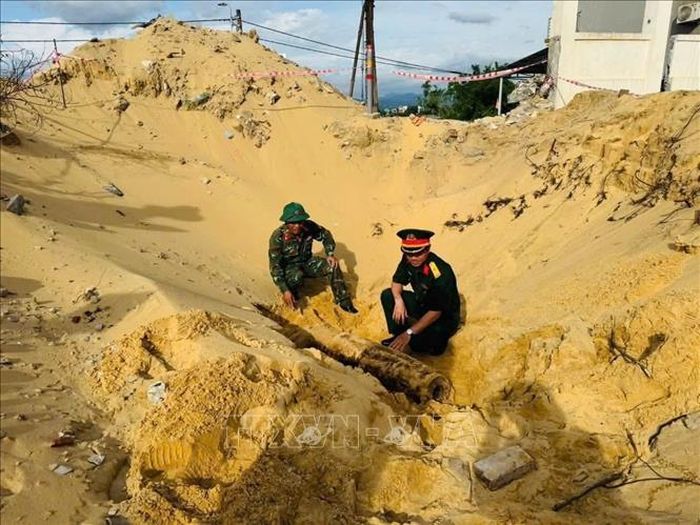 Với sự hỗ trợ của Bộ Chỉ huy Quân sự tỉnh Quảng Trị, lực lượng chức năng tiến hành khảo sát, xử lý di dời an toàn quả bom theo đúng quy định. Ảnh: TTXVN phát