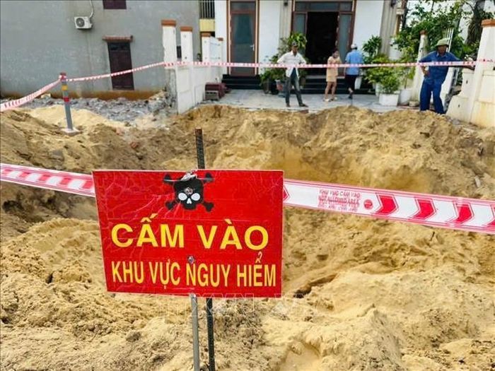 Lực lượng chức năng lập rào chắn, tổ chức canh gác 24/24 giờ, bảo vệ và giữ nguyên hiện trường, không để người dân và các phương tiện tiếp cận khu vực phát hiện bom. Ảnh: TTXVN phát