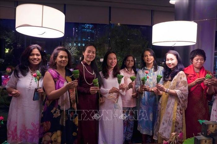 Đại sứ Trịnh Thị Tâm (thứ 4, từ trái sang) cùng các nữ doanh nhân hai nước giới thiệu sản phẩm ướp trà theo sự hướng dẫn của Nghệ nhân Lâm Diệu Linh. Ảnh: TTXVN phát