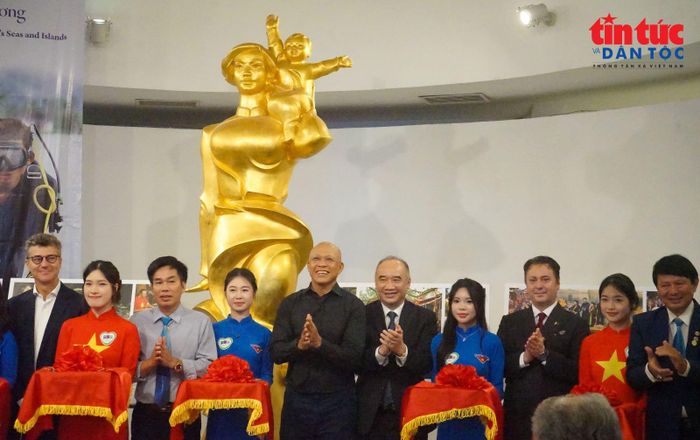 Các đại biểu, khách mời cắt băng khai mạc triển lãm ảnh.