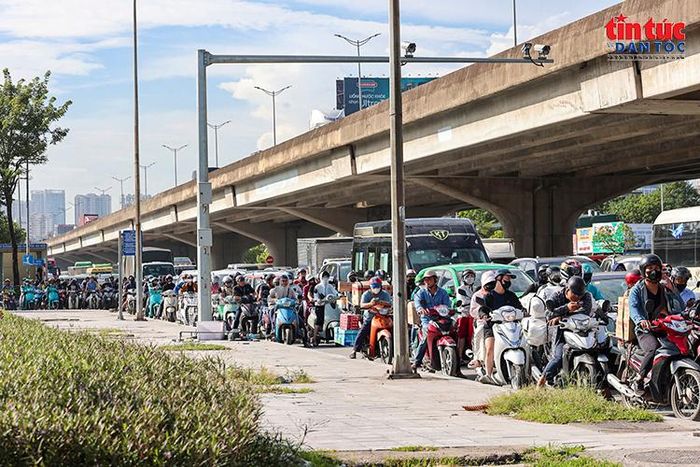 Dòng xe máy nối dài dưới đường Vành đai 2 trên cao trong thời điểm giao thông đông đúc.
