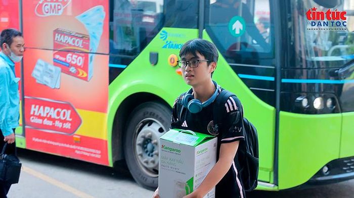 Hành khách mang theo đồ đạc lên xe khách, bắt đầu hành trình rời Hà Nội về quê nghỉ lễ.