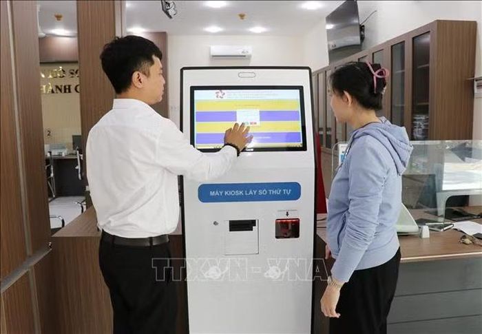 Cán bộ Trung tâm phục vụ hành chính công phường Phan Rang (Khánh Hòa) hướng dẫn người dân đăng ký thông tin giải quyết thủ tục hành chính. Ảnh: Nguyễn Thành/TTXVN