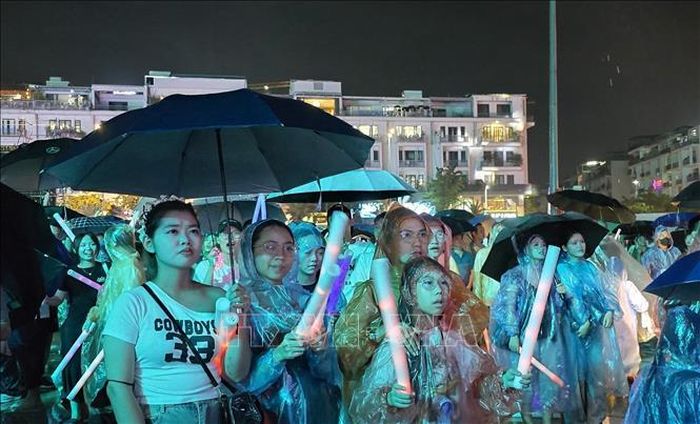 Nhân dân và du khách đội mưa thưởng thức “Quảng Ninh - Thành phố rạng rỡ tương lai”.
