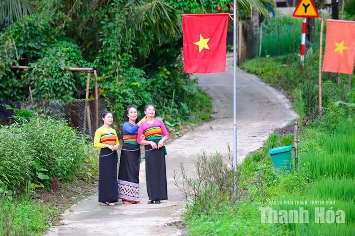 Trên cung đường quanh co, cờ Tổ quốc tạo thành những điểm đỏ nổi bật giữa màu xanh của cây rừng.