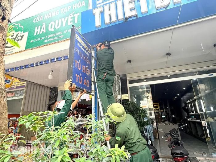 Các lực lượng chức năng tiến hành tháo dỡ các biển quảng cáo lắp đặt không đúng quy định tại đường Lê Lai, phường Quảng Phú
