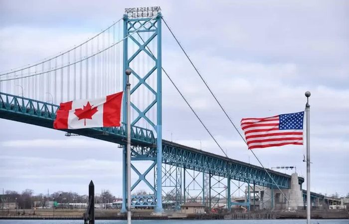 Cờ Canada và Mỹ tung bay gần cầu Ambassador tại cửa khẩu biên giới Canada - Mỹ ở Windsor, Ontario. Cây cầu này từ lâu đã là hành lang thương mại giữa Canada và Mỹ. Ảnh: Winnipegfreepress.