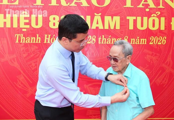 Phó Bí thư Thường trực Tỉnh ủy Nguyễn Hồng Phong gắn Huy hiệu 80 năm tuổi Đảng lên ngực áo đảng viên Đỗ Hùng Lâm.