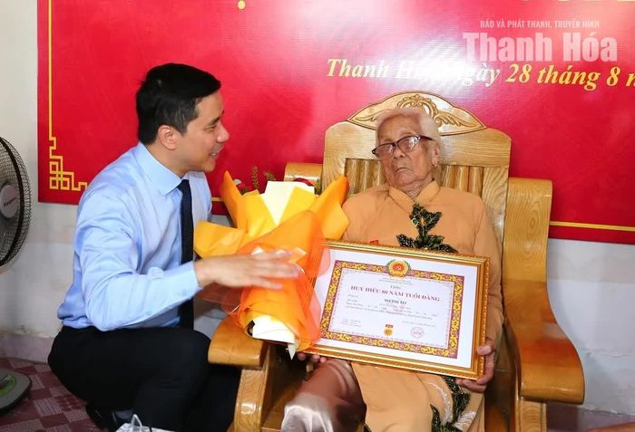 Phó Bí thư Thường trực Tỉnh ủy Nguyễn Hồng Phong trao Huy hiệu 80 năm tuổi Đảng, Quyết định của Ban Bí thư và tặng hoa chúc mừng đảng viên Đỗ Thị Tít.