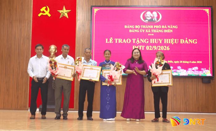 Lãnh đạo xã Thăng Điền trao Huy hiệu 45 năm tuổi Đảng và tặng hoa chúc mừng các đảng viên. Ảnh: GIANG BIÊN