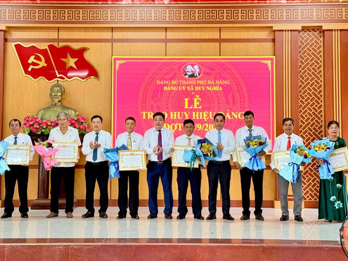 Thường trực Đảng ủy xã Duy Nghĩa trao huy hiệu 35 năm tuổi Đảng cho các đảng viên. Ảnh: TUYẾT MAI