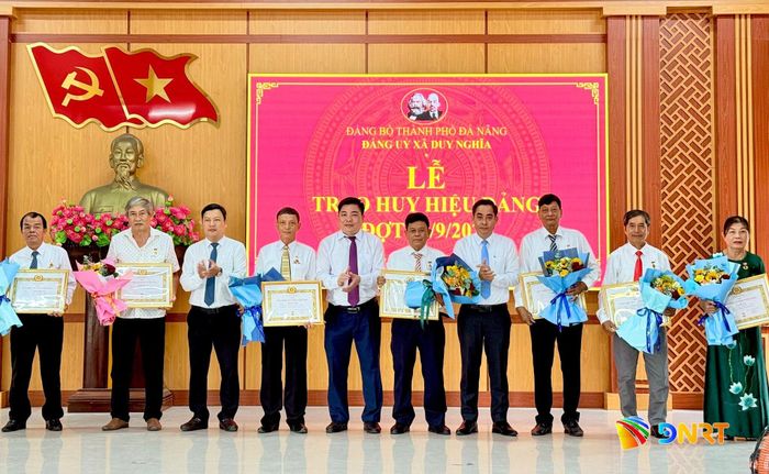 Thường trực Đảng ủy xã Duy Nghĩa trao Huy hiệu 35 năm tuổi Đảng cho các đảng viên. Ảnh: TUYẾT MAI