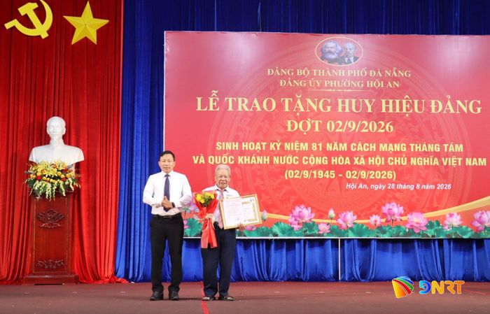 Trưởng ban Tổ chức Thành ủy Đoàn Duy Tân trao Huy hiệu 60 năm tuổi Đảng cho đảng viên Trần Đình Tạo. Ảnh: QUỐC TUẤN