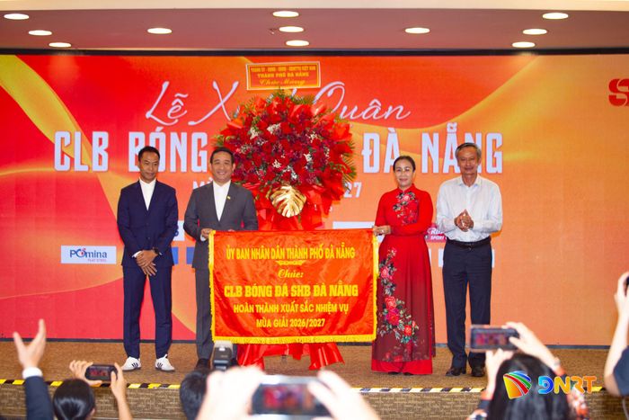 Lãnh đạo thành phố trao cờ chúc đội bóng hoàn thành xuất sắc nhiệm vụ mùa giải 2026 - 2027. Ảnh: BẢO LÂM