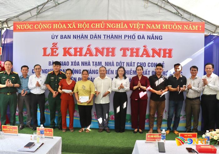 Lãnh đạo thành phố và các đơn vị, địa phương tặng quà chúc mừng các gia đình nhân dịp bàn giao nhà. Ảnh: QUỐC TUẤN