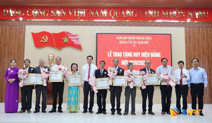 Trưởng ban Nội chính Thành ủy Võ Công Chánh (thứ 2, bên phải sang) và lãnh đạo xã Tam Mỹ trao Huy hiệu 35 năm tuổi Đảng cho đảng viên. Ảnh: X.THƯƠNG