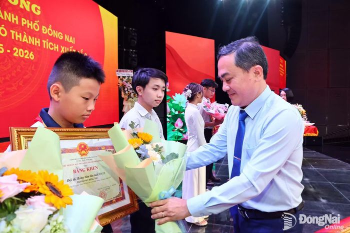 Ủy viên Ban Thường vụ Thành ủy, Phó Chủ tịch UBND thành phố Lê Trường Sơn trao khen thưởng của UBND thành phố cho các em học sinh có thành tích xuất sắc. Ảnh: Công Nghĩa