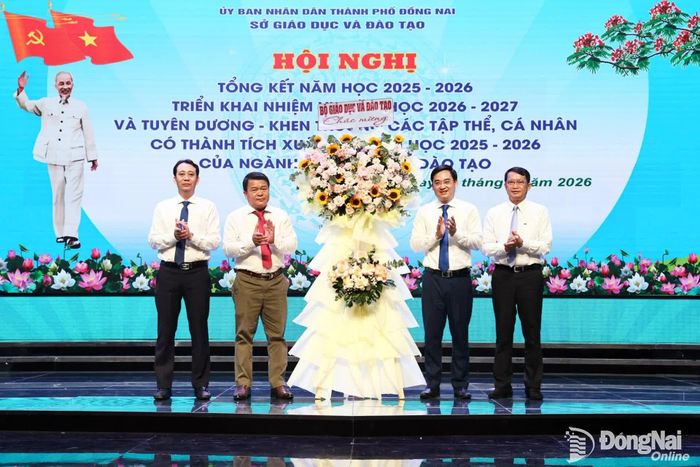 Ông Lê Thắng Lợi, Giám đốc Trung tâm Phát triển Giáo dục và Đào tạo phía Nam, Văn phòng Bộ Giáo dục và Đào tạo tại Thành phố Hồ Chí Minh trao hoa của Bộ Giáo dục và Đào tạo chúc mừng ngành giáo dục thành phố Đồng Nai. Ảnh: Công Nghĩa