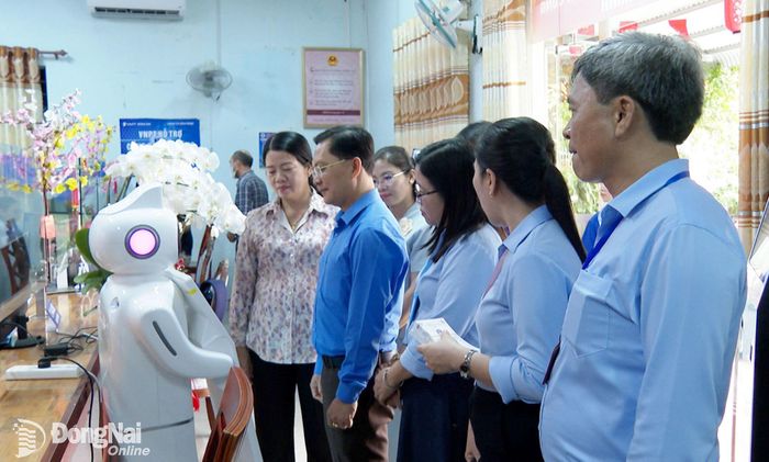 Đoàn công tác trải nghiệm robot AI tại Trung tâm Phục vụ hành chính công xã Bình Minh. Ảnh: Phạm Quang