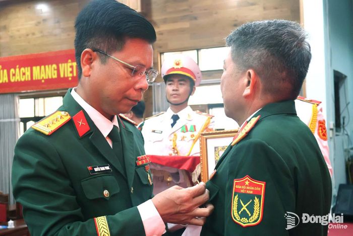 Đại tá Nguyễn Thanh Phong, Thành ủy viên, Phó Bí thư Thường trực Đảng ủy Quân sự, Chính ủy Bộ Chỉ huy Quân sự thành phố trao Huy hiệu Đảng cho Đại tá Nguyễn Văn Dũng. Ảnh: Nguyệt Hà