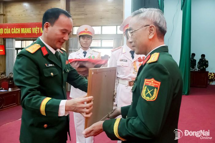 Đại tá Võ Thành Danh, Ủy viên Ban Thường vụ Thành ủy, Phó Bí thư Đảng ủy Quân sự thành phố, Chỉ huy trưởng Bộ Chỉ huy Quân sự thành phố trao Huy hiệu Đảng cho Đại tá Phạm Khắc Toán. Ảnh: Nguyệt Hà