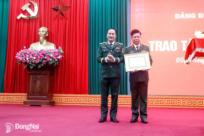 Đại tá Võ Thành Danh, Ủy viên Ban Thường vụ Thành ủy, Phó Bí thư Đảng ủy Quân sự thành phố, Chỉ huy trưởng Bộ Chỉ huy Quân sự thành phố trao Huy hiệu Đảng cho Đại tá Nguyễn Thanh Phong. Ảnh: Nguyệt Hà