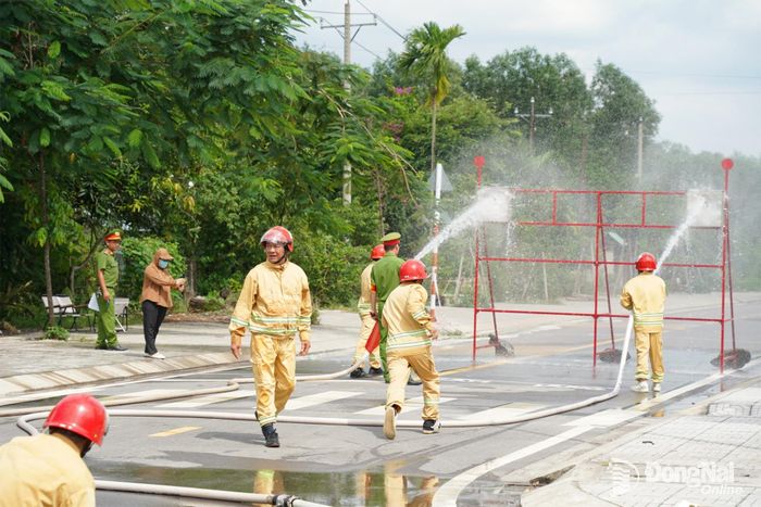 Thành viên đội phòng cháy, chữa cháy cơ sở thực hiện nội dung kiểm tra đội hình máy bơm chữa cháy 2 lăng B phun tiêu điểm. Ảnh: Lê Duy