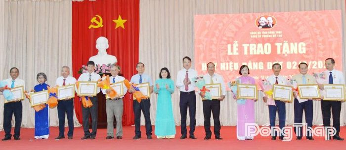 Đồng chí Phạm Thị Mai Tiên trao Huy hiệu Đảng cho các đảng viên.