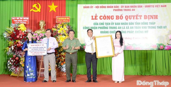 Thiếu tướng Lâm Phước Nguyên trao Quyết định của Chủ tịch UBND tỉnh Đồng Tháp công nhận Trung An là phường An toàn khu và trao biểu trưng bảo hiểm y tế toàn dân cho phường Trung An.