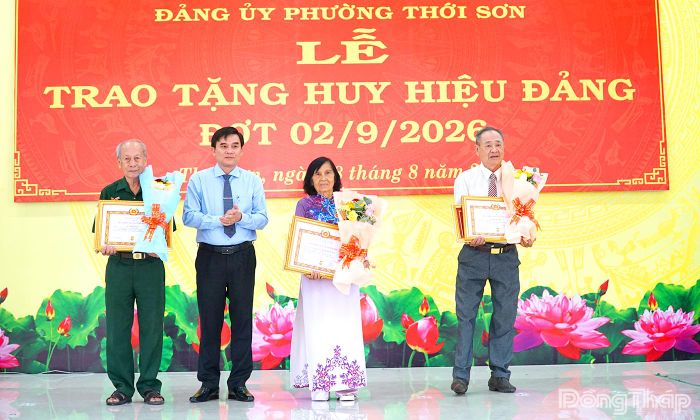 Đồng chí Nguyễn Văn Mười trao Huy hiệu 65 năm và 60 năm tuổi Đảng cho các đảng viên.