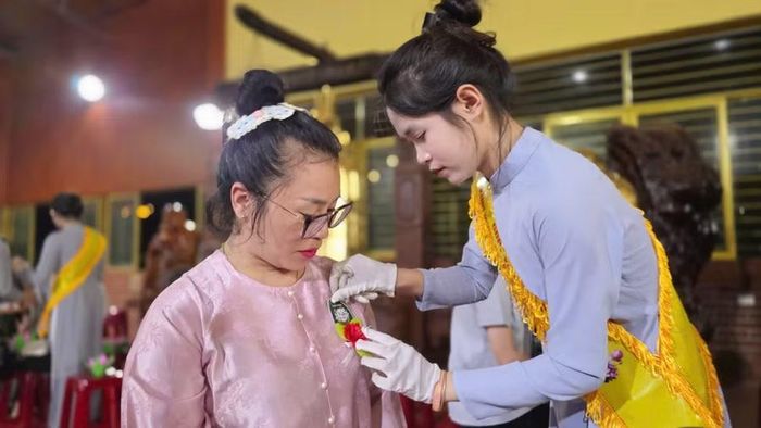  Từng đóa hoa hồng được cài lên ngực áo, nhắc mỗi người con về công ơn sinh thành, dưỡng dục và biết trân trọng những người thân yêu khi còn có thể. Ảnh: Bá Bính 