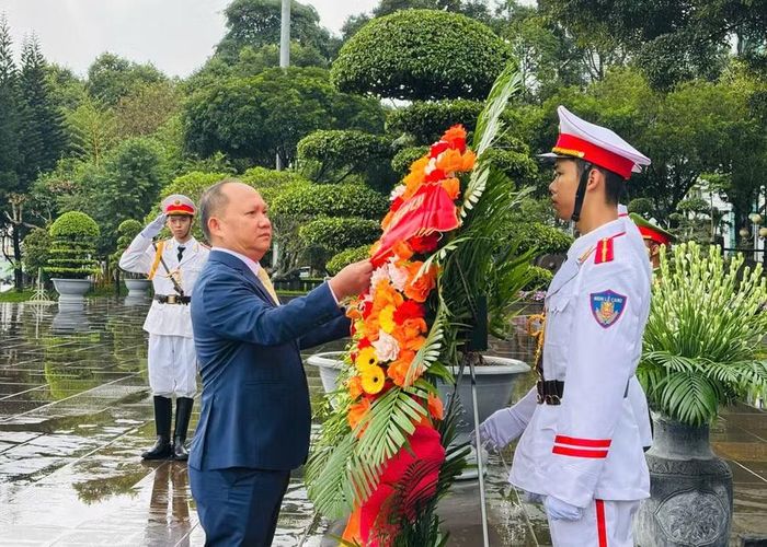  Đồng chí Rah Lan Chung chỉnh vòng hoa, thực hiện nghi thức dâng hoa tại Tượng đài Bác Hồ với các dân tộc Tây Nguyên. Ảnh: P.D 
