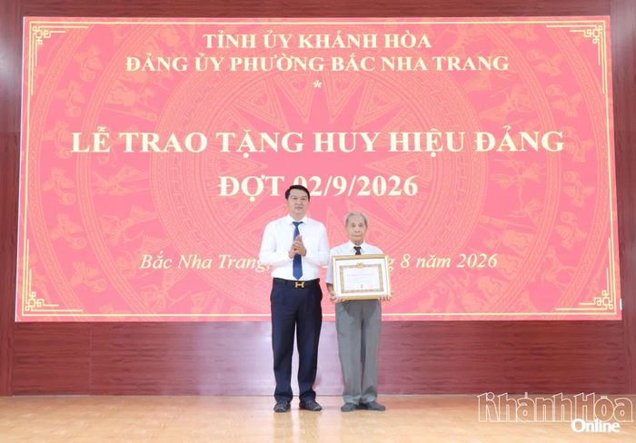 Đồng chí Lương Đức Hải trao Huy hiệu 65 năm tuổi Đảng cho đảng viên.
