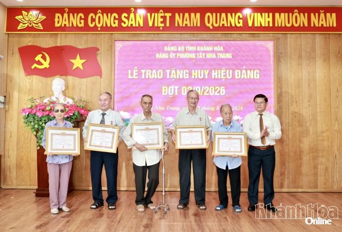 Lãnh đạo Đảng ủy phường Tây Nha Trang trao tặng Huy hiệu Đảng cho các đảng viên.