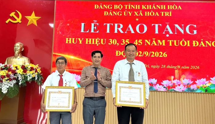 Ông Nguyễn Hữu Nam - Phó Bí thư Đảng ủy, Chủ tịch UBND xã trao Huy hiệu 30 năm tuổi Đảng cho các đảng viên.