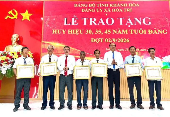 Thường trực Đảng ủy xã Hòa Trí trao Huy hiệu 35 tuổi Đảng cho các đảng viên.