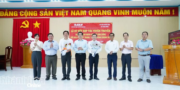 Lãnh đạo xã Anh Dũng tặng hoa chúc mừng 2 đơn vị ký kết hợp tác tuyên truyền.