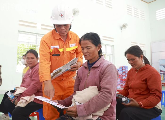 Nhân viên Truyền tải điện Khánh Hòa phát tờ rơi và hướng dẫn cho người dân.