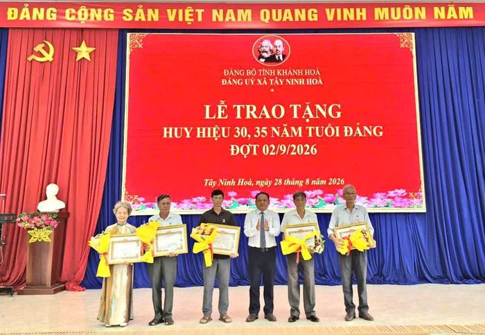 Ông Nguyễn Ngọc Hiếu - Phó Bí thư Thường trực Đảng ủy xã trao Huy hiệu 35 tuổi Đảng cho các đảng viên.