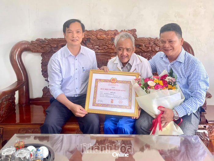 Đại diện lãnh đạo Ban Xây dựng Đảng trao tặng Huy hiệu 50 năm tuổi Đảng cho đảng viên Mấu Lợi thuộc Chi bộ thôn Ba Cụm Nam. 